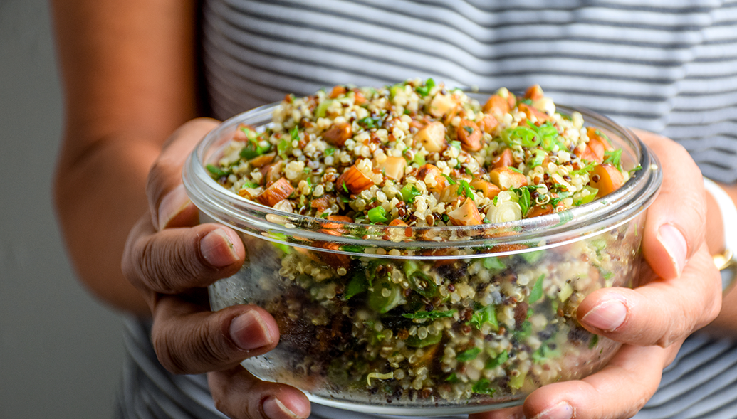 Person holding bowl of food.